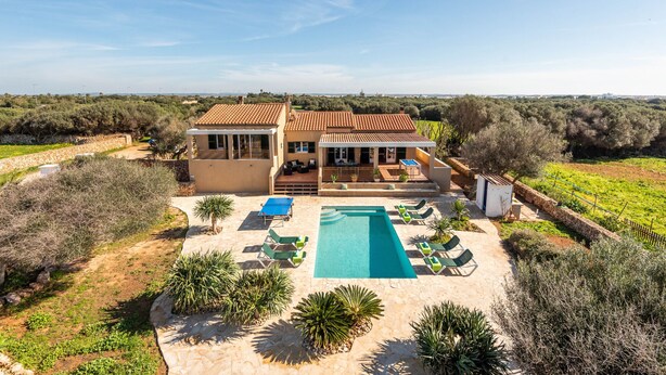 Una villa con piscina, zona de estar exterior y vistas al campo.