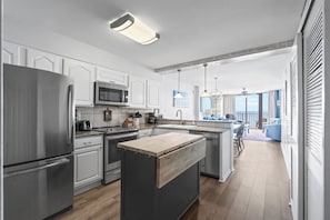 Una cocina moderna con electrodomésticos de acero inoxidable, una isla de madera y vistas a un balcón.