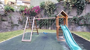 A playground with a slide and a climbing structure.