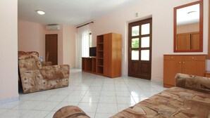 A spacious living room with a sofa, a TV stand, and a cabinet.