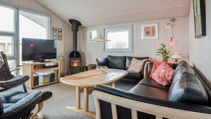 A cozy living room with a fireplace, leather sofa, and a television. - 3 bedroom cozy home in Hemmet (Hemmet)