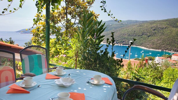 Mesa para dos con vista al mar y colinas.