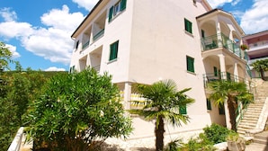 A multi-story building with balconies and a staircase.