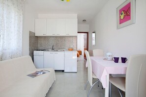 Cozy living space with a kitchenette, dining table, and sofa.