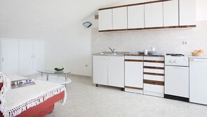 A compact kitchen with white cabinets, a small countertop, and a dishwasher. - Apartment 2024/28742 (Istria - Rabac), 1200m from the beach (Rabac)