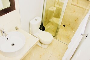 Bathroom features a sink, toilet, and shower area with a glass enclosure.