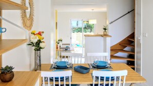 Un comedor con una mesa de madera, sillas azules y un jarrón de flores.