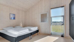 A bedroom with a bed, a window, and a view of the outdoors. - Nice home in Løkken with sauna (Løkken)