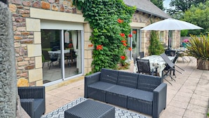Un espace patio aménagé avec des meubles en osier, une table et des chaises.