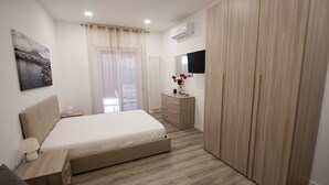 Une chambre à coucher moderne, comprenant un lit, une table de chevet, une commode et une armoire.