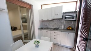 Une cuisine compacte équipée d’un four à micro-ondes, d’un évier et d’un coin repas avec une table et des chaises.