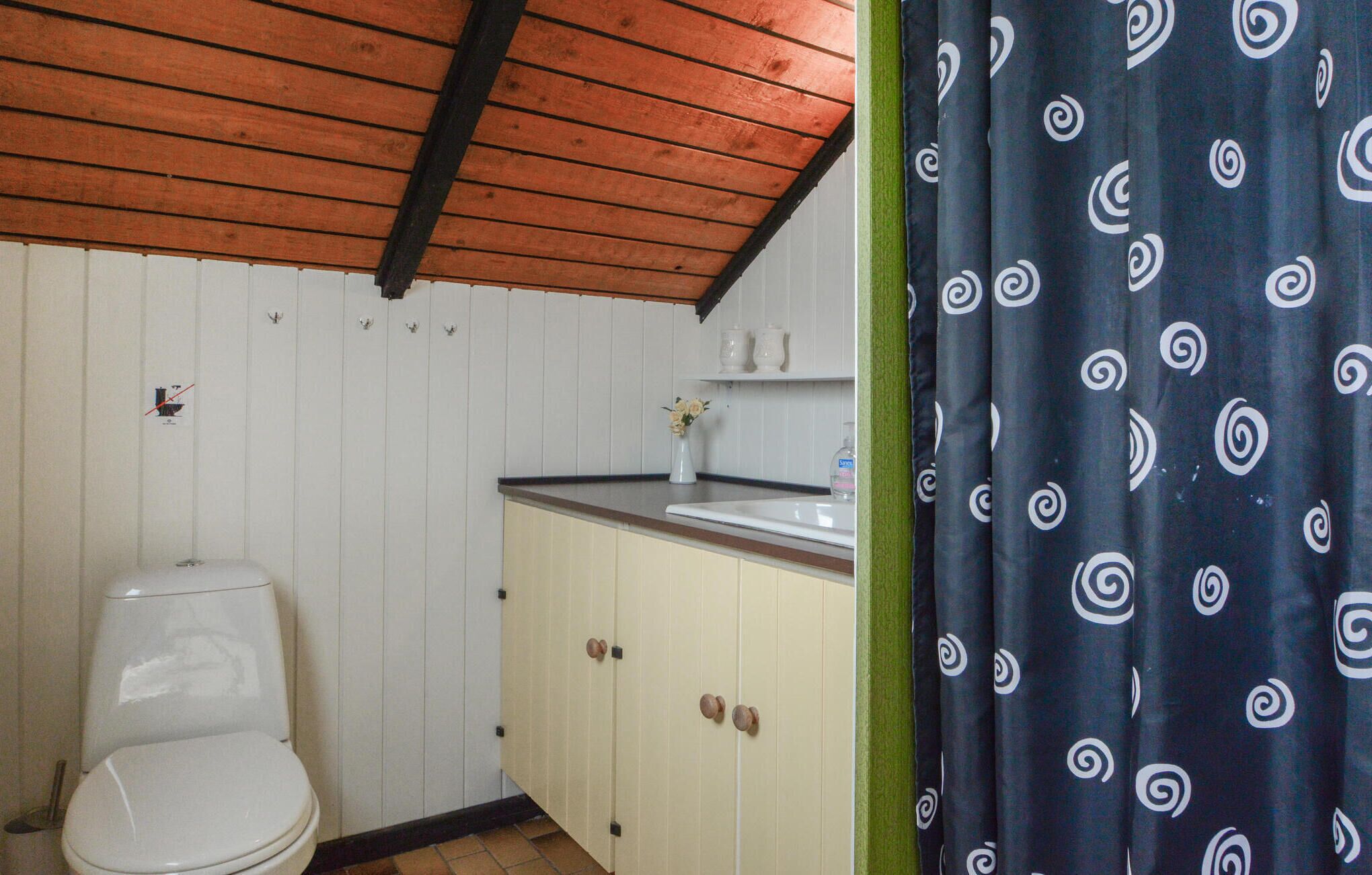 Une petite salle de bain avec des toilettes, un lavabo et des placards.