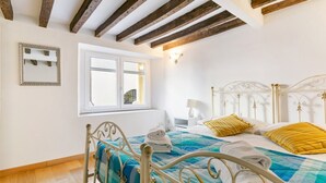 A bedroom with a bed, a window, and a mirror.