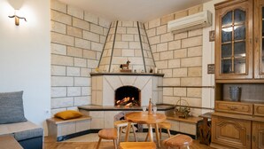 A cozy living room with a stone fireplace, wooden furniture, and a built-in cabinet. - Amazing home in Runovic (Runovic)