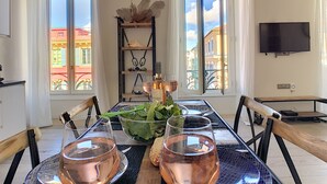 A dining area with a table set for two, a bowl of salad, and two glasses of wine. - N&J - MASSENA DREAM - Hyper center - Close sea (Niza)