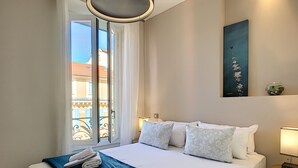 A hotel room with a bed, a window, a painting, and a small table with a lamp. - N&J - MASSENA DREAM - Hyper center - Close sea (Niza)