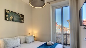 A hotel room with a bed, a painting, a balcony with a view of buildings, and a window with curtains. - N&J - MASSENA DREAM - Hyper center - Close sea (Niza)
