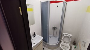 A modern bathroom with a glass-enclosed shower, a sink, and two toilets. - Have your own privacy with total comfort at a very low price. (Kyiv)