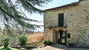 Un edificio de piedra con un pequeño balcón, una puerta y una ventana.