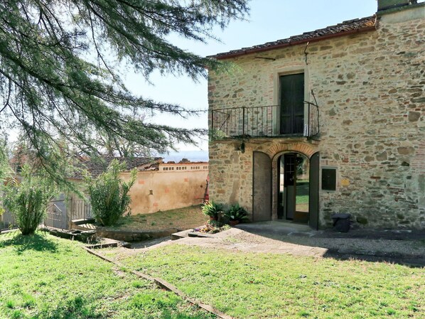 Un bâtiment en pierre doté d’un petit balcon, d’une porte et d’une fenêtre.
