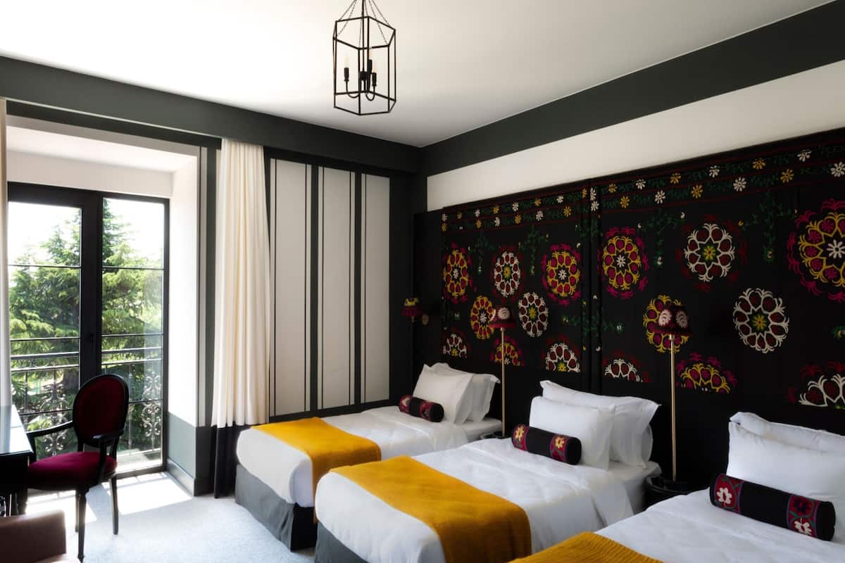 Une chambre d’hôtel avec deux lits, un bureau et une chaise.