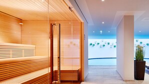 A modern spa area with wooden benches and a glass partition. - Beautiful apartment for 6 people with WIFI, pool, TV, balcony, pets allowed and panoramic view (Feichtinger)