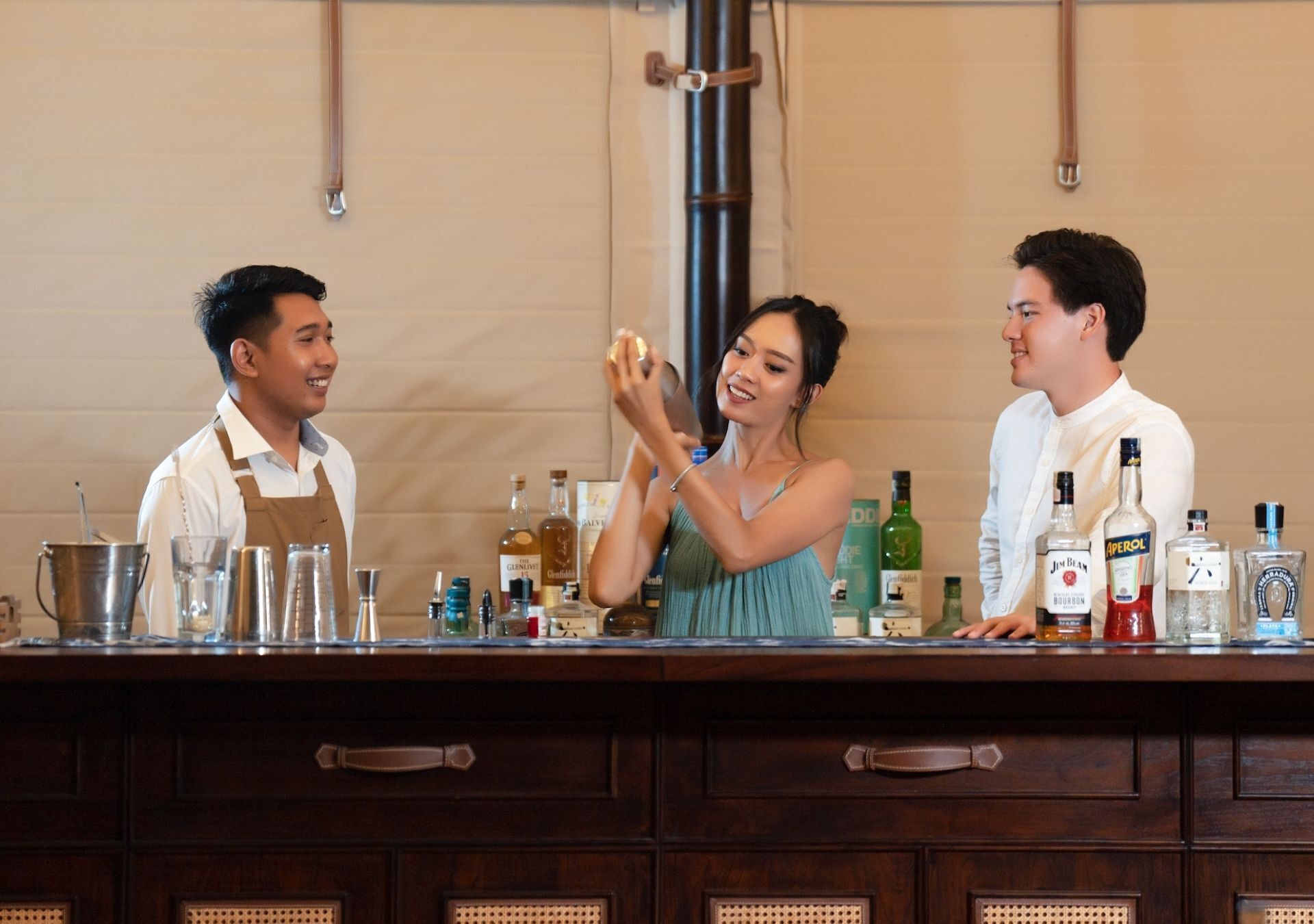 A bar with a counter, bottles, and glasses.