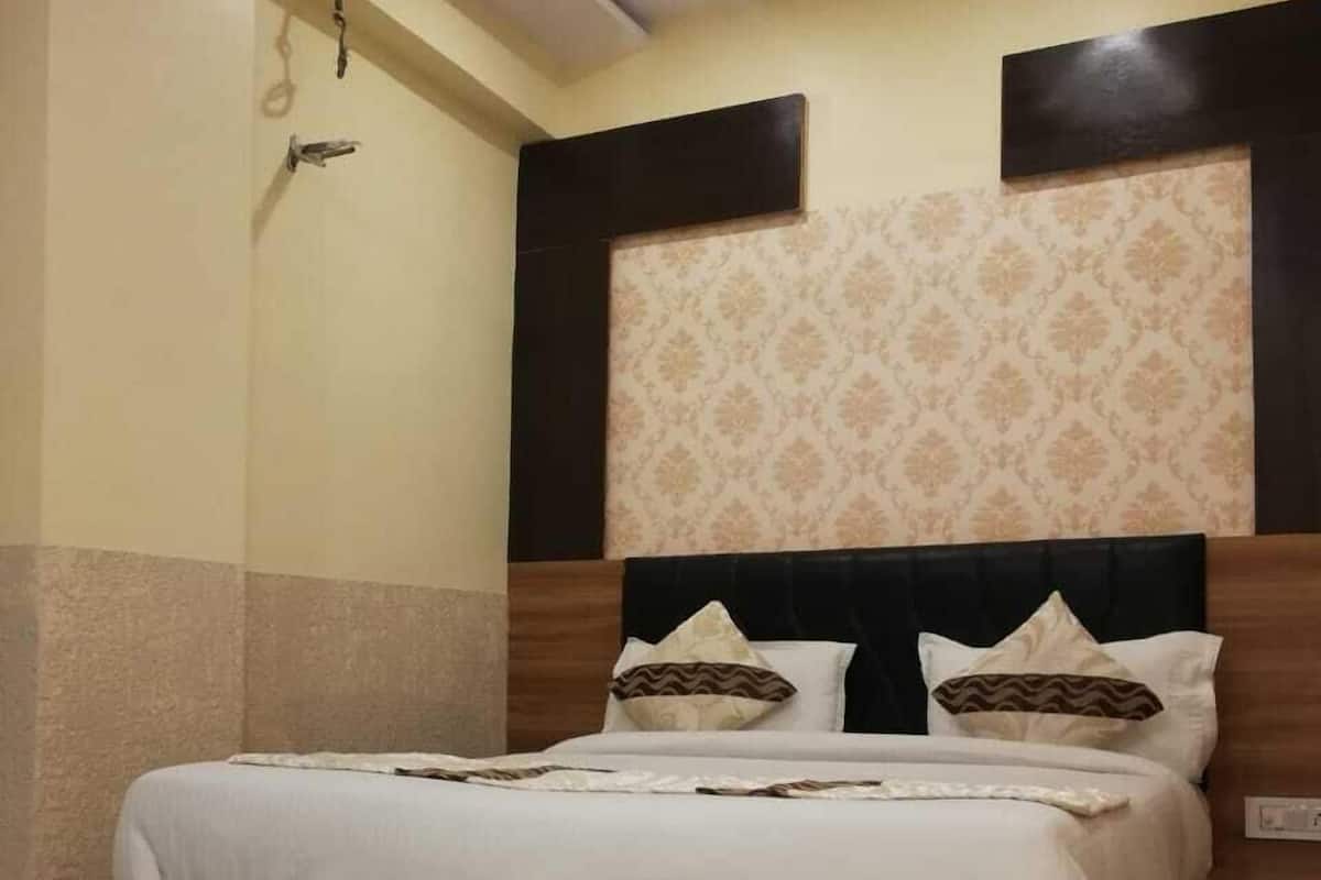Un dormitorio con estructura de cama de madera, cabecera estampada y suelo de mármol.