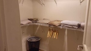 Une buanderie équipée d’un lave-linge, d’un étendoir et d’un panier à linge.