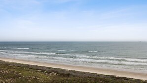 A beach with a sandy shore and ocean waves. - Sandpiper Condominiums 902, Panoramic Gulf Views w/ direct access to Mustang Island/Port A beaches. (Port Aransas)
