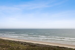 Ein Strand mit sandigem Ufer und Meereswellen.