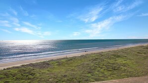 En strand med klart himmel og en vej der fører til kysten.