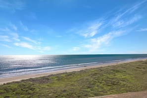 A beach with a clear sky and a road leading to the shore.