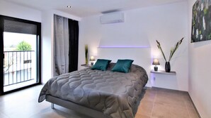 A modern bedroom with a large bed, a balcony, and a painting on the wall. - Beautiful home in Salon de Provence (Salon de Provence)