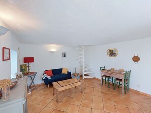 A living room with a sofa, coffee table, and dining table with chairs.