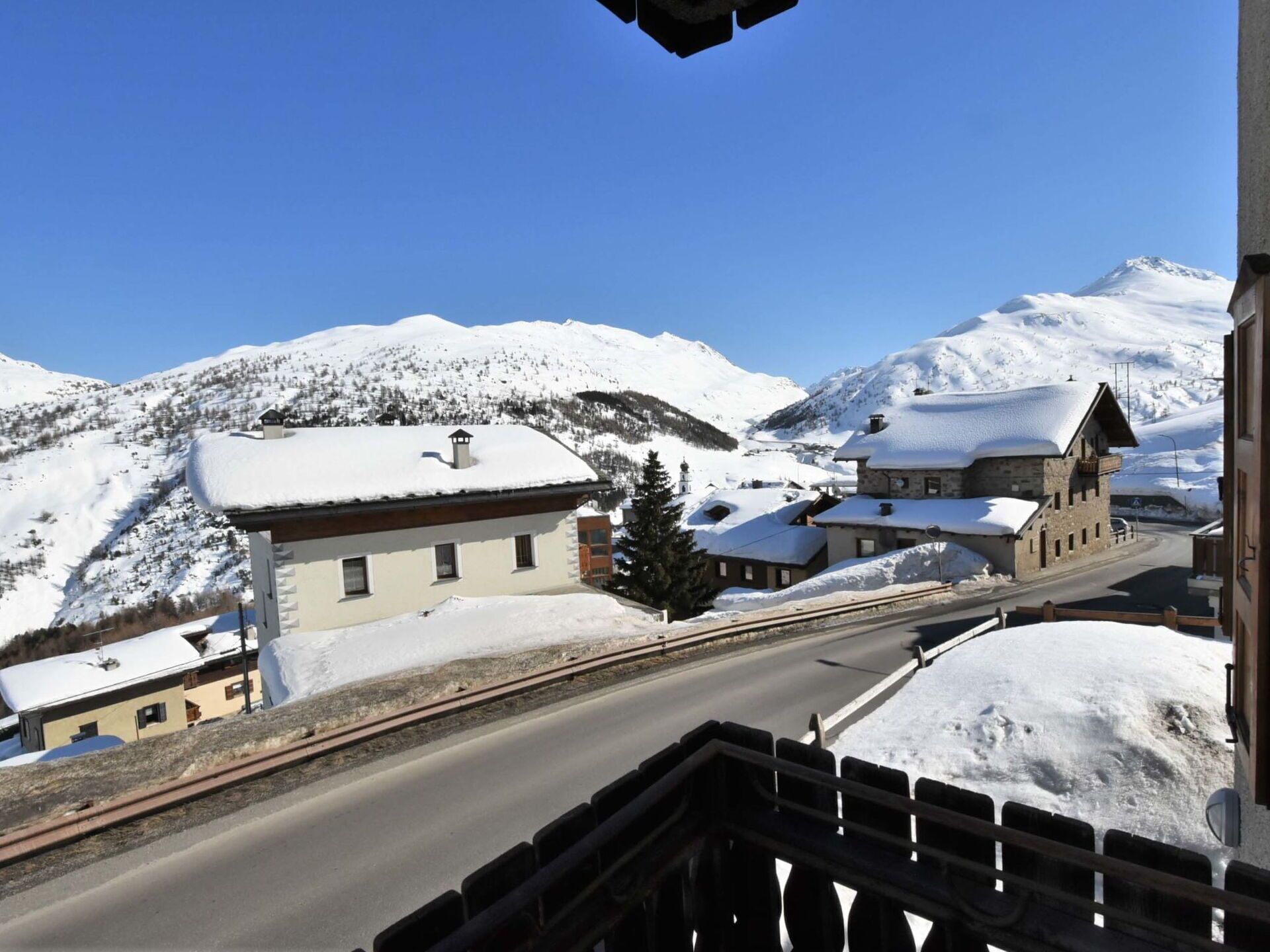 A snow-covered mountain village with traditional buildings and a clear sky.
