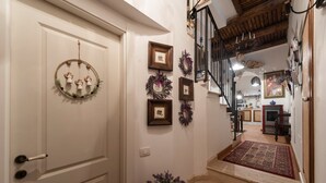 A staircase leading to a kitchen with a wooden ceiling and a red rug. - La Casa degli Angeli B&B (Salerno)