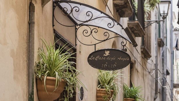 A narrow street with a building featuring a sign reading "La casa degli Angeli B&B". - La Casa degli Angeli B&B (Salerno)