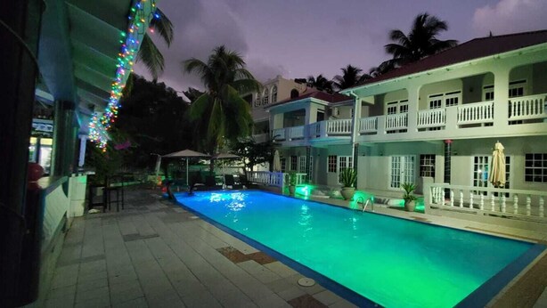 Un hôtel doté d’une piscine, de nombreux balcons et situé dans un cadre tropical.