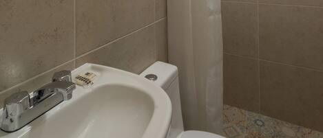 A bathroom with a sink, toilet, and shower curtain.