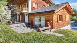 A wooden chalet with a balcony, a stone staircase, and a wooden deck. - Cosy apartment for 7 people with WIFI, TV and balcony (Les Collons)