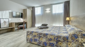 Ein modernes Hotelzimmer mit einem großen Bett, einem Schreibtisch und einem Stuhl.