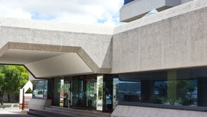 A modern building with a unique architectural design, featuring a sloped roof and large glass windows. - Hotel San Juan Park (San Juan del Río)