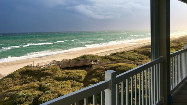 A beach view from a balcony with a wooden deck and railing. - Once Upon a Tide: FULL RENO for 2026! Oceanfront, Pool, Linens (Indian Beach)