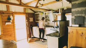 A rustic kitchen with wooden beams, a stove, and a sink.