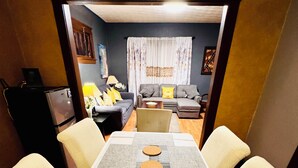 A dining area with a long table, four chairs, and a central yellow basket. - Rainbow Inn on the Walnut Avenue ,  3bed room, 2full bath, double parking, WiFi  (Niagara Falls)