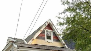 A single-story house with a gabled roof, a front porch, and a well-maintained green hedge. - Great views in OTR, lots of parking & big yard! (Cincinnati)