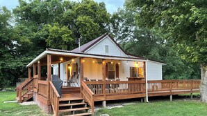 A two-story house with a porch, a covered deck, and a small staircase leading to the upper level. - Confluence Cabin Grafton, IL (Grafton)