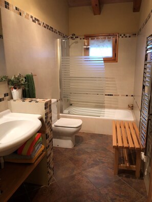 Bathroom features a pedestal sink, toilet, and bathtub with shower enclosure.