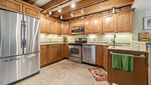 A kitchen with wooden cabinets, stainless steel appliances, and a tiled floor. - Sea Horse Cottage-5 Bedrooms, 3 Full Baths, 2 Half Baths, Sleeps 14 (West Cape May)